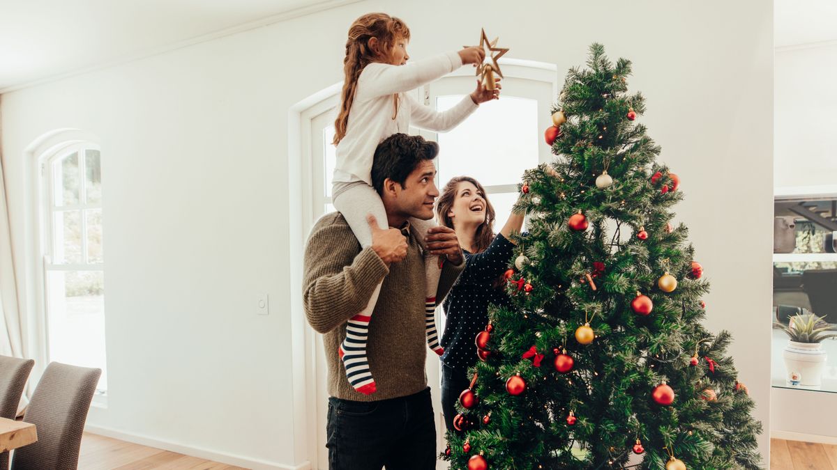 Family,Decorating,A,Christmas,Tree.,Young,Man,With,His,Daughter