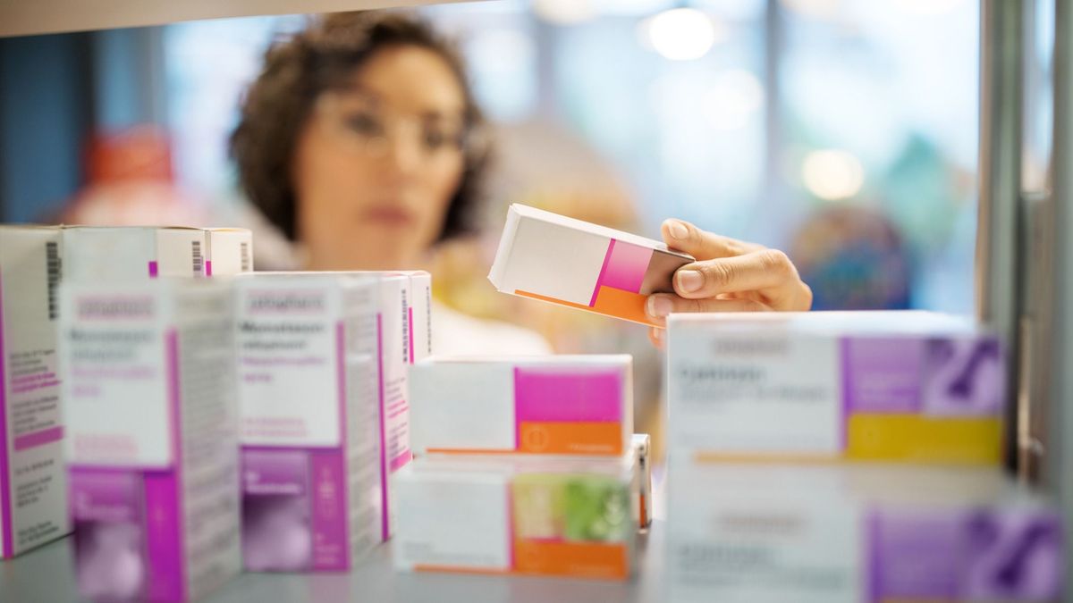 Female pharmacist checking medicines on rack