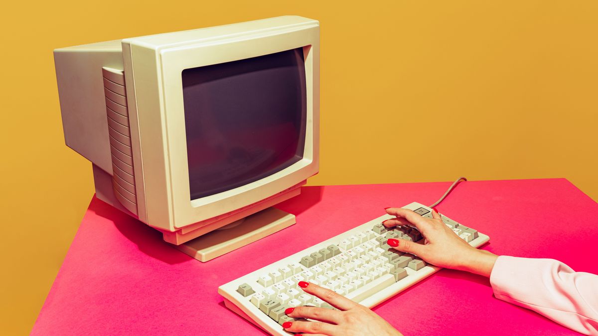 Colorful image of vintage computer monitor and keyboard on bright pink tablecloth over yellow background. Typing information