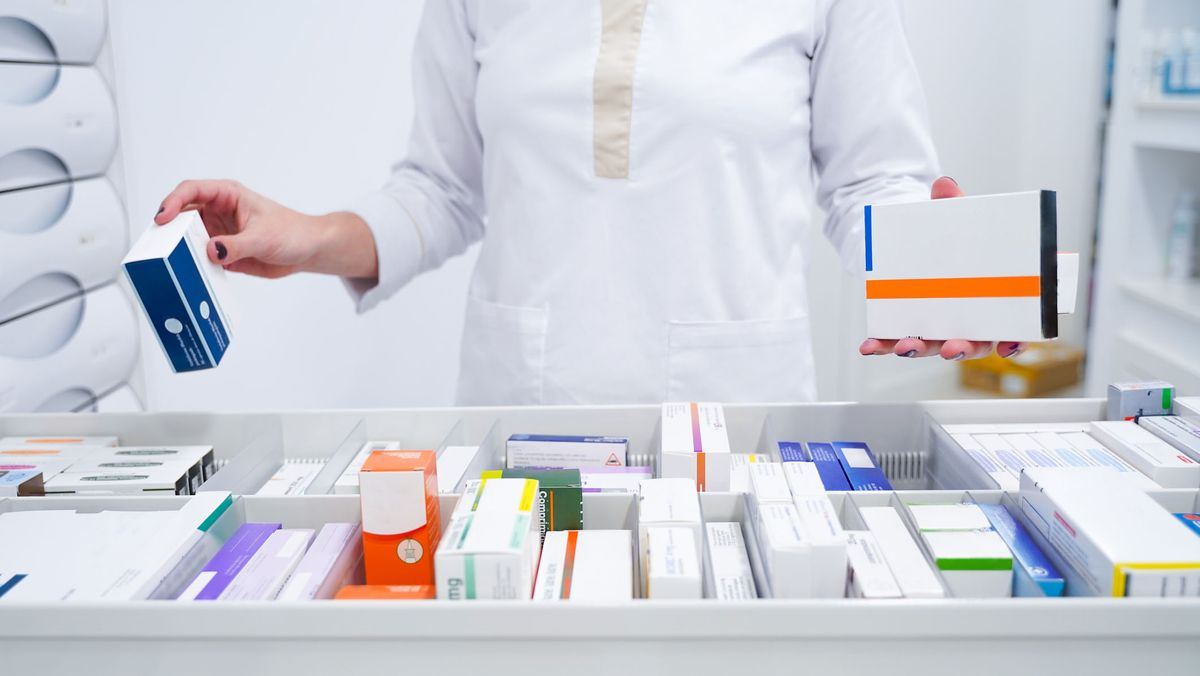 Young pharmacist looking for medicines in the drawer