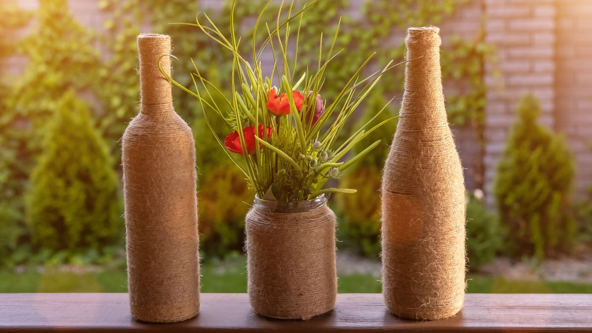 Two,Bottles,And,A,Vase,Of,Flowers,Braided,With,Linen