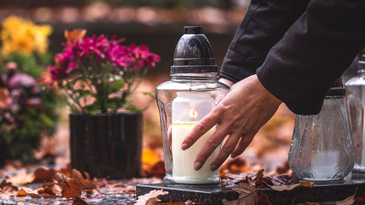 Woman,Is,Putting,Candle,Lantern,At,Grave,In,Cemetery.,Grief