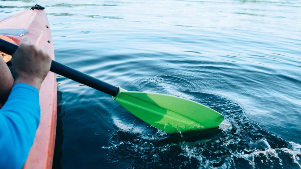 kayaker paddles across a serene lake