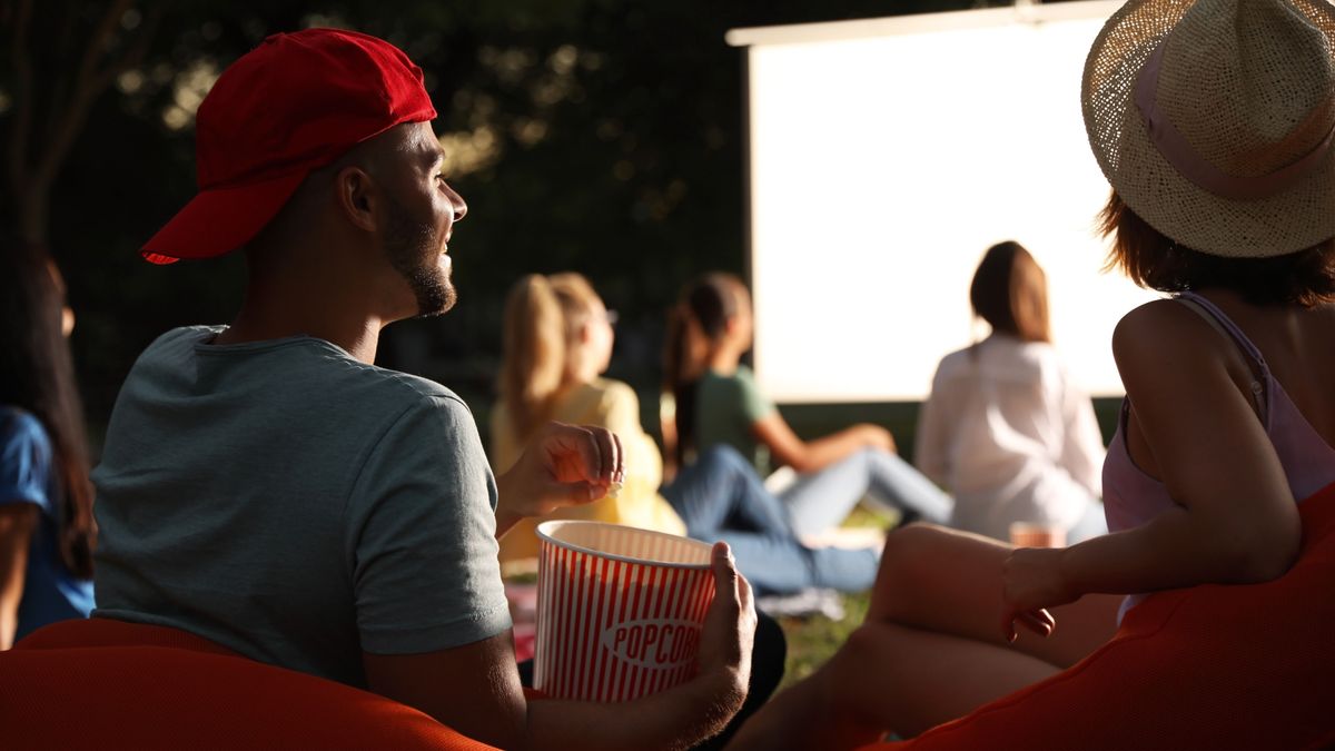 Young,Couple,With,Popcorn,Watching,Movie,In,Open,Air,Cinema.