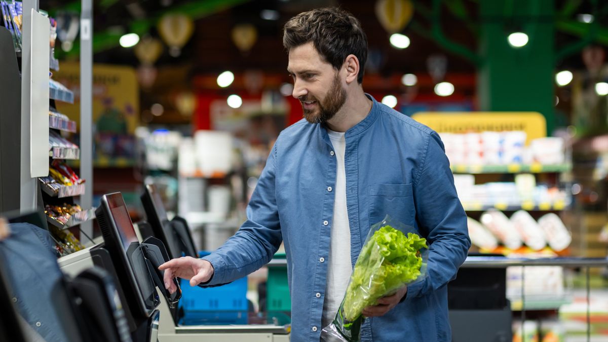 Adult,Male,In,A,Blue,Shirt,Using,A,Self-checkout,Machine