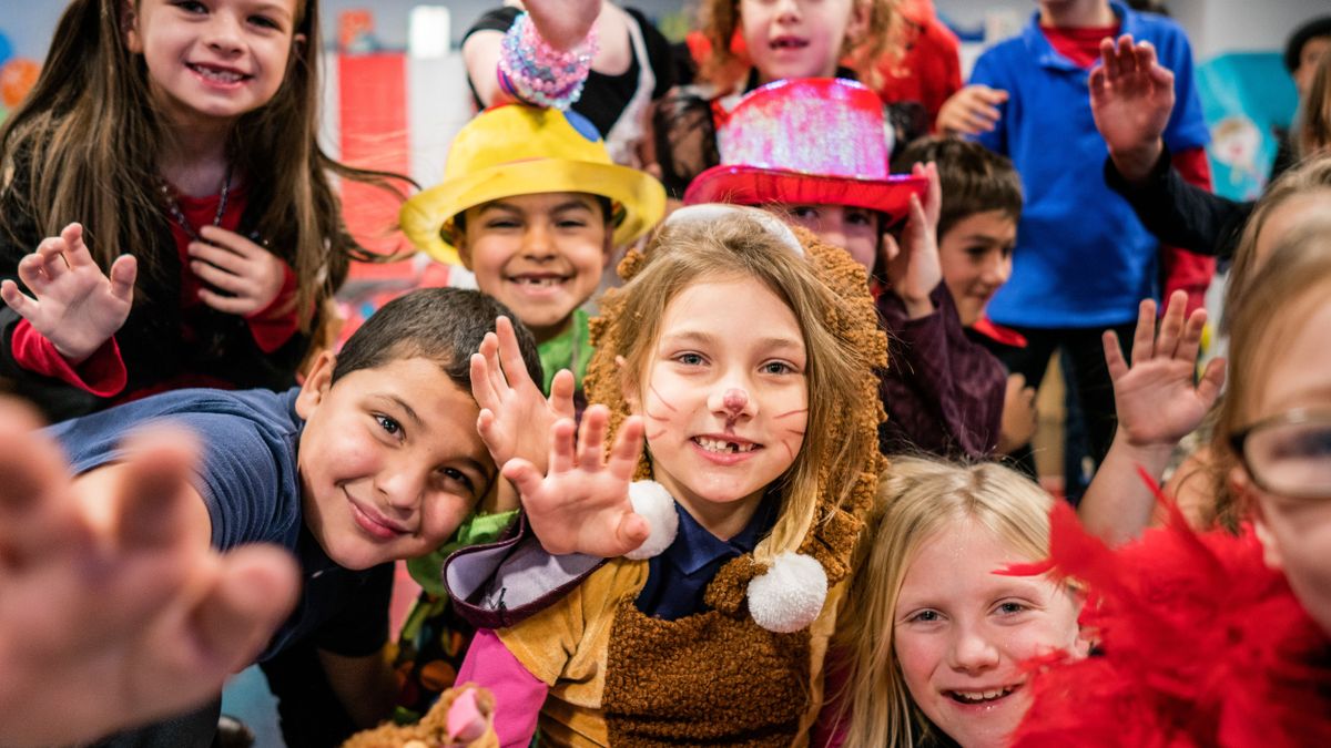 Students in circus costumes performing in theater