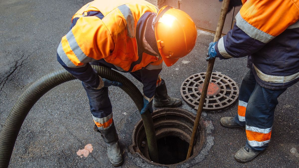 Sewer,Workers,Cleaning,Manhole,And,Unblocking,Sewers,The,Street,Sidewalk.