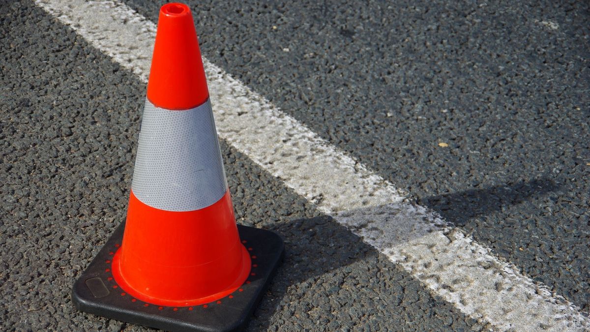 Traffic cone next to the line marking on the shoulder of a road