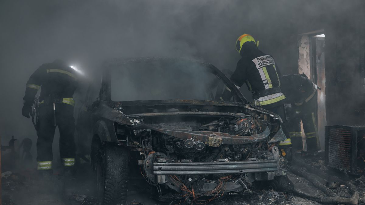 Firefighters,Extinguish,A,Burning,Car,In,A,Garage.,Burnt,Car.