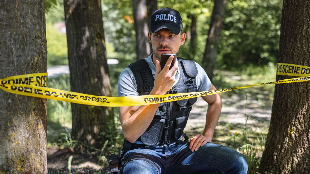 Policeman Using Smart Phone On Crime Scene